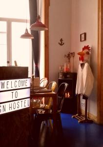 a chicken statue in a living room with a sign at Goodnight Hostel in Lisbon