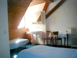 ein Schlafzimmer mit einem Bett, einem Waschbecken und einem Fenster in der Unterkunft Hôtel-Buffet de la Gare in Chateau-d'Oex