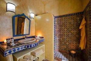 een badkamer met een wastafel en een spiegel bij Riad Emotion in Essaouira +75 foto's