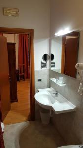 La salle de bains est pourvue d'un lavabo et d'un miroir. dans l'établissement Airone Pisa Park Hotel, à Pise