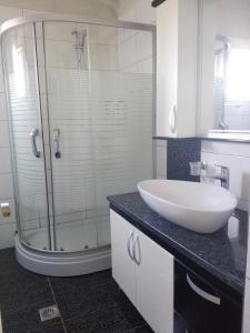 a bathroom with a sink and a glass shower at Vip Apartment by "Murati" in Ksamil