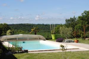 una piscina con giardino d'inverno in vetro in giardino di Gîte d'en Pouillac a Saint-Thomas