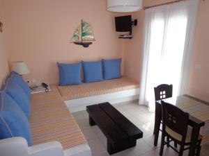 sala de estar con almohadas azules y sofá en Blue Harmony Apartments en Plaka