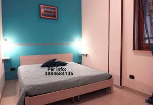 ein Schlafzimmer mit einem Bett und einer blauen Wand in der Unterkunft Bilocale Blu - A casa di Ludovica e Martina in Gallipoli + 3 Fotos