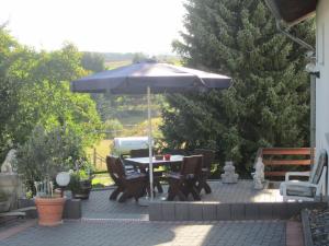 a table and chairs under an umbrella on a patio at Haus Alexander in Mechernich