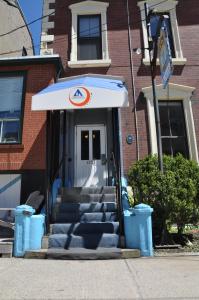 a front door of a building with stairs and an umbrella at HI Halifax - Hostel in Halifax