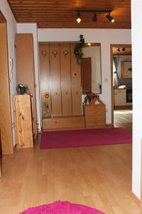 ヒルシャイトにあるFerienwohnung Schützの木製ロッカーと紫の敷物が備わる客室です。