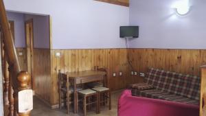 a living room with a couch and a table at Apartamentos Picu Castiellu in La Galguera