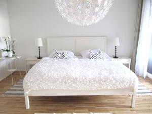 ein Schlafzimmer mit einem weißen Bett und einem Kronleuchter in der Unterkunft Ferienwohnung Lac Konstanz in Konstanz