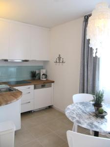 a kitchen with white cabinets and a table at Ferienwohnung Lac Konstanz in Konstanz