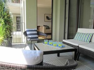 a patio with a couch and a table with glasses on it at Ferienwohnung Lac Konstanz in Konstanz +2 photos