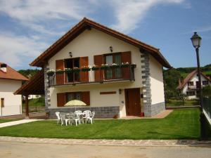 a house with a table and chairs in front of it at Albergue Irugoienea in Espinal-Auzperri