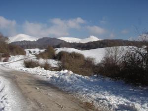a snow covered road with mountains in the background at Albergue Irugoienea in Espinal-Auzperri