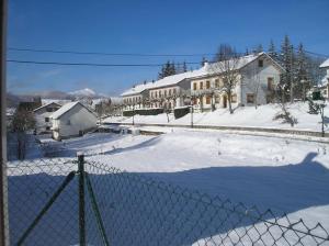 a fence in front of a house in the snow at Albergue Irugoienea in Espinal-Auzperri