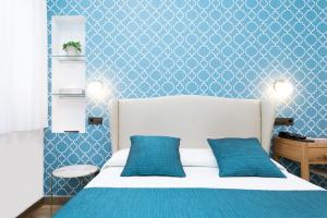 een slaapkamer met een wit bed en blauwe muren bij Hostal Oriente in Madrid