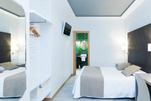 a bedroom with two beds and a mirror at Hostal Oriente in Madrid