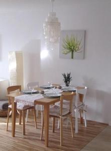 - une table à manger, des chaises, une table et une plante dans l'établissement Ferienwohnung Lac Konstanz, à Constance