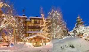 un resort ricoperto di neve con un edificio sullo sfondo di Lodge Park a Megève