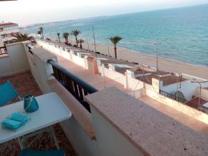 een balkon met een tafel en uitzicht op het strand bij PLAYA 1 - PRIMERA PRIMERA LINEA DE PLAYA in Pilar de la Horadada