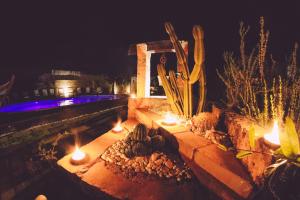 un giardino con candele e cactus in un cortile di notte di Villa con Piscina by Corallo Blu Salento a Taviano
