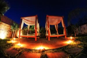 2 sedie su un patio di notte con luci di Villa con Piscina by Corallo Blu Salento a Taviano