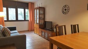 a living room with a couch and a tv and a table at Apartament Esterri Centre in Esterri d'Àneu