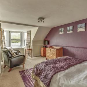 a bedroom with a bed and a chair and a dresser at TwoStones in Arrochar