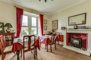 a dining room with a table and a fireplace at TwoStones in Arrochar