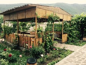 a garden with a wooden building with flowers at Mina Hotel in Goris