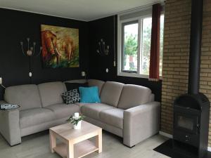 een woonkamer met een bank en een open haard bij Bungalows Dellewal in West-Terschelling
