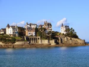a group of houses on a hill next to the water at Jacques MELCHIOR meublé de tourisme 3 étoiles Intra Muros in Saint Malo