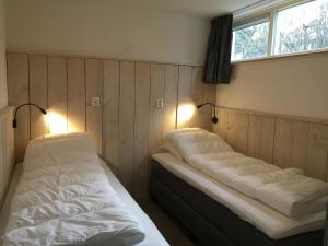 
a bedroom with a bed and a lamp at Bungalows Dellewal in West-Terschelling
