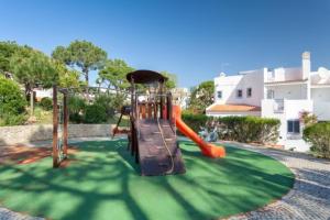a playground with an orange slide on a green field at Modern 2 Bed Apartment Vale do Lobo in Vale do Lobo