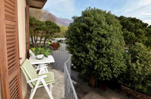 einen Balkon mit 2 Stühlen, einem Tisch und einem Baum in der Unterkunft Appartamento Castello in Cannobio