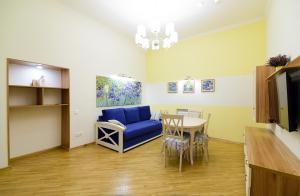 a living room with a blue couch and a table at VIP апартаменти Ван Гог на площі Ринок in Lviv