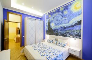 a bedroom with a large painting on the wall at VIP апартаменти Ван Гог на площі Ринок in Lviv