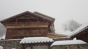 a snow covered building with a balcony on top of it at Arpege Des Neiges in Sainte-Foy-Tarentaise