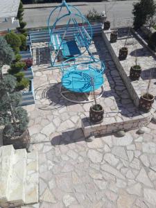 a blue playground with potted plants on a stone ground at Vip Apartment by "Murati" in Ksamil