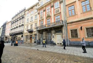a group of people standing in front of a building at VIP апартаменти Ван Гог на площі Ринок in Lviv