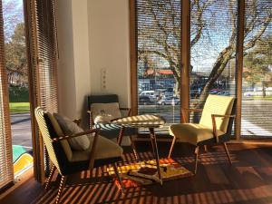 a living room with chairs and a table and windows at Baltic Beach Retreat in Nida +12 photos