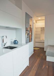 eine Küche mit weißen Schränken und einem Waschbecken im Zimmer in der Unterkunft Baltic Beach Retreat in Nida