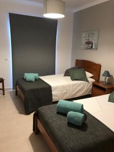 a bedroom with two beds with green pillows at Apartamento T&T Ocean - Vista Mar in Portimão