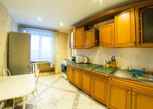 オムスクにあるRENT-сервис Apartment Serovaのキッチン(木製のキャビネット、テーブル付)