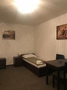 Zimmer mit einem Bett und einem Tisch in der Unterkunft Apartament Parkowy in Brwinów
