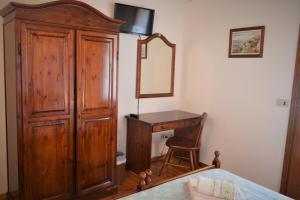 a bedroom with a wooden dresser and a mirror at Colja Jozko Agriturismo in Samatorza