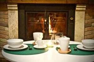 a table with plates and cups on a table with a fireplace at B&B mò•sì in Massa dʼAlbe +33 photos