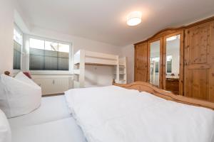ein Schlafzimmer mit einem weißen Bett und einem Etagenbett in der Unterkunft Villa Mona Lisa Whg. 6 in Göhren