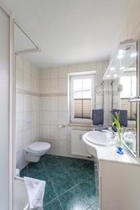 ein Badezimmer mit einem Waschbecken, einem WC und einer Badewanne in der Unterkunft Villa Mona Lisa Whg. 6 in Göhren