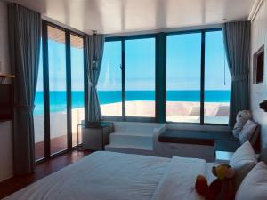 1 dormitorio con 1 cama y vistas al océano en Sea Shore Hotel, en Manzhou