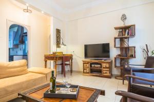 a living room with a couch and a tv at Family House next to Acropolis in Athens